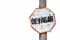 Ã¢â¬ÅDevagarÃ¢â¬Â in Portuguese, slow or slowly written in a rusty and grungy white and red old weathered road traffic sign